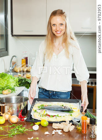 woman cooking fish with potato in sheet pan 9782953