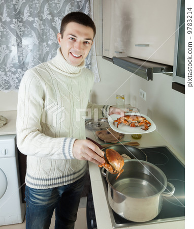 Handsome guy holding raw crabs 9783214