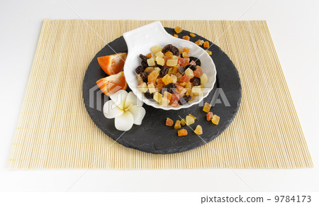 Dried fruits on stone plate with flower 9784173