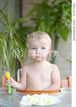 Adorable toddler girl eating healthy food, steamed vegetables 9787599