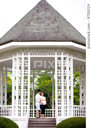 Beautiful happily married couple sharing a tender moment in a gazebo. Beautiful happily married couple sharing a tender moment in a gazebo. 9789324