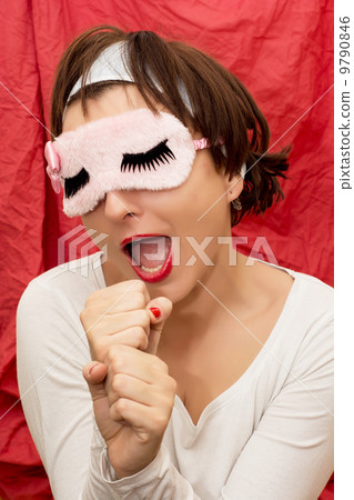 Attractive woman in sleeping mask imitates singing into a microp Attractive woman in sleeping mask imitates singing into a microp 9790846