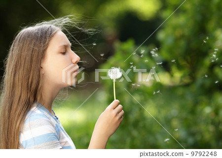 teenage girl blowing a dandelion 9792248
