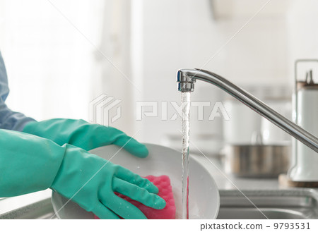 A woman washing dishes with rubber gloves. A woman washing dishes with rubber gloves. 9793531
