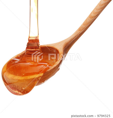 Honey dripping from a wooden honey dipper isolated on white back 9794325