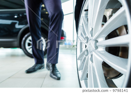 Young man or auto dealer in car dealership 9798141