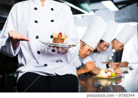 Asian Chef in restaurant kitchen cooking Asian Chef in restaurant kitchen cooking 9798344