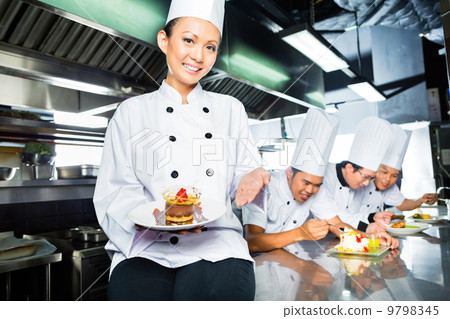 Asian Chef in restaurant kitchen cooking Asian Chef in restaurant kitchen cooking 9798345