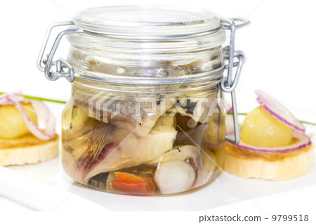 pickled herring in a glass jar with potato canapes pickled herring in a glass jar with potato canapes 9799518
