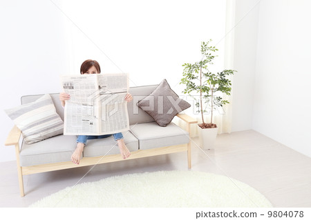 A cute little woman relaxing reading newspaper A cute little woman relaxing reading newspaper 9804078