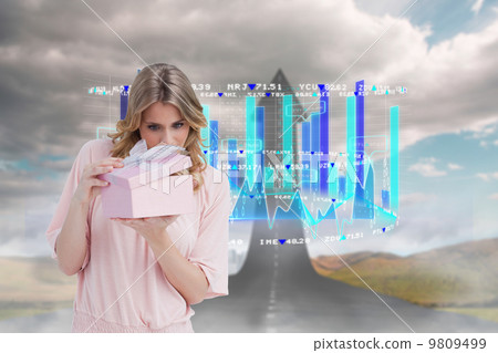 Composite image of curious young woman holding a gift while open 9809499