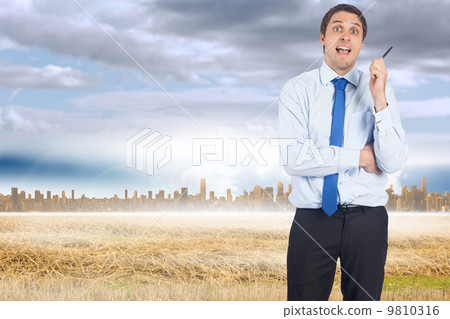 Composite image of thinking businessman holding pen 9810316