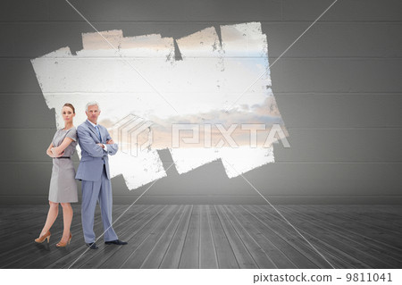 Composite image of serious businessman standing back to back wit 9811041