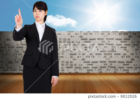 Composite image of focused businesswoman pointing 9812026