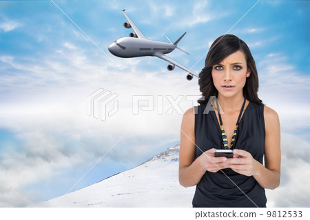 Composite image of serious elegant brown haired model texting Composite image of serious elegant brown haired model texting 9812533