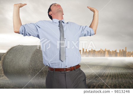Composite image of businessman standing with hands up 9813246