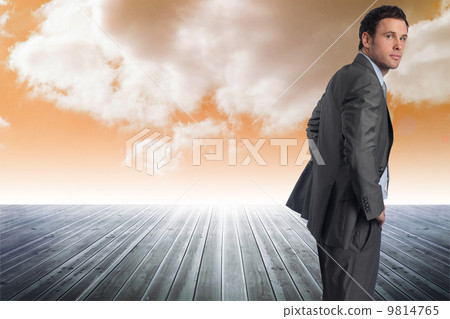 Composite image of serious businessman with hands on hips Composite image of serious businessman with hands on hips 9814765