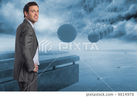 Composite image of smiling businessman with hand on hip Composite image of smiling businessman with hand on hip 9814978