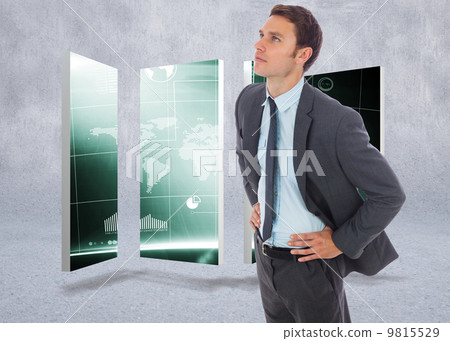 Composite image of serious businessman standing with hands on hi 9815529