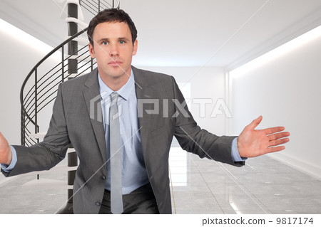 Composite image of businessman posing with hands out 9817174