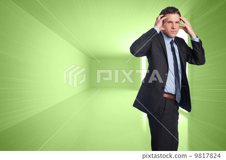 Composite image of stressed businessman with hands on head 9817824