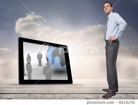 Composite image of smiling businessman with hand on hip 9818256