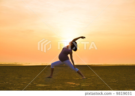 pregnant mother performing yoga on outdoor beach 9819031