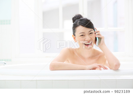 A girl who speaks on a smartphone while taking a bath A girl who speaks on a smartphone while taking a bath 9823189