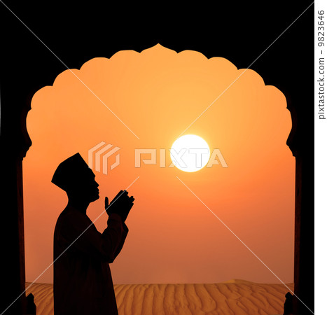 silhouette of a muslim male praying on the desert 9823646