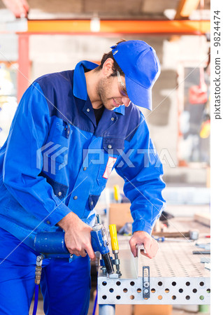 Craftsman rivet metal in workshop 9824474