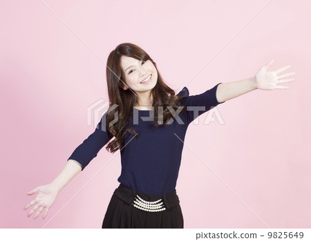 A young woman with a smile spreading her hands 9825649