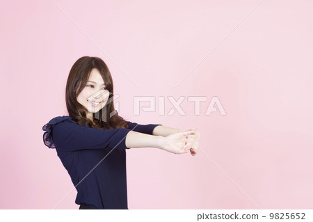 A young woman smiling with her hand stretched out 9825652
