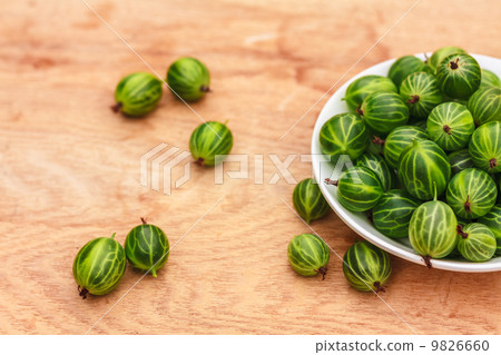 Close-Up Of Gooseberries In Vintage White Dish On Wooden Table Close-Up Of Gooseberries In Vintage White Dish On Wooden Table 9826660