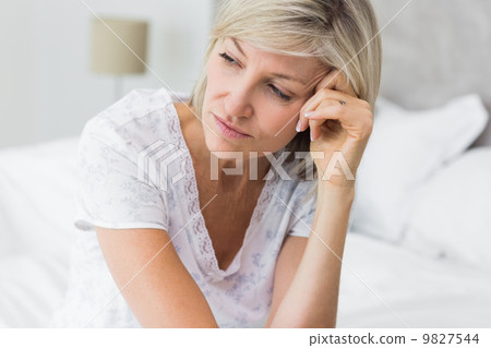Tensed mature woman sitting in bed 9827544