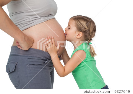 Little girl kissing her mothers baby bump Little girl kissing her mothers baby bump 9827649