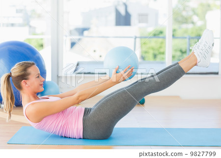Sporty young woman stretching body in fitness studio 9827799