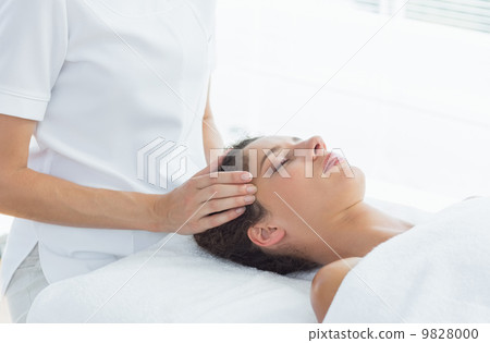 Woman receiving head massage from therapist Woman receiving head massage from therapist 9828000