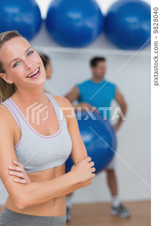 Young woman with friends in background at fitness studio Young woman with friends in background at fitness studio 9828040