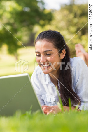 Smiling woman using laptop in park Smiling woman using laptop in park 9828097