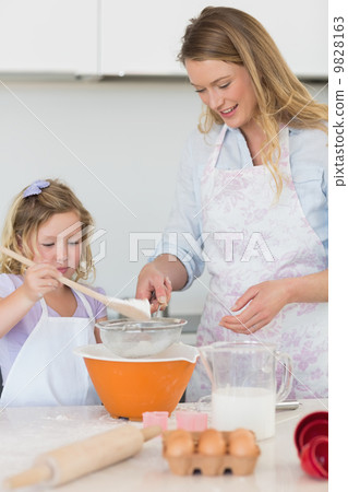 Mother teaching daughter to make cookies 9828163