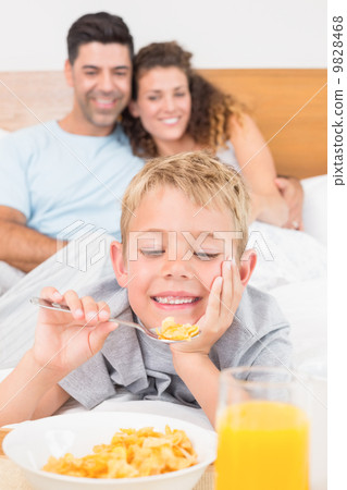 Cute young family having breakfast in bed Cute young family having breakfast in bed 9828468