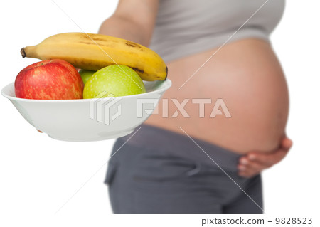 Pregnant woman showing fruit bowl to camera Pregnant woman showing fruit bowl to camera 9828523
