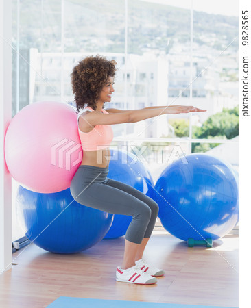 Sporty woman with exercise ball in fitness studio Sporty woman with exercise ball in fitness studio 9828565