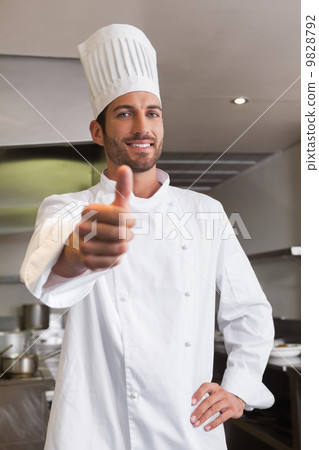 Happy young chef looking at camera showing thumb up 9828792
