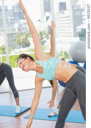 Sporty women stretching hands at yoga class 9829207