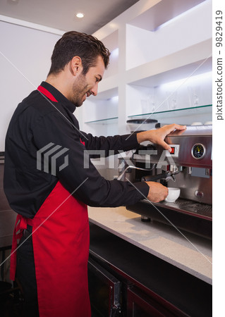 Smiling attractive barista making cup of coffee 9829419