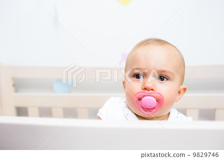Closeup of a cute baby with pacifier in mouth Closeup of a cute baby with pacifier in mouth 9829746
