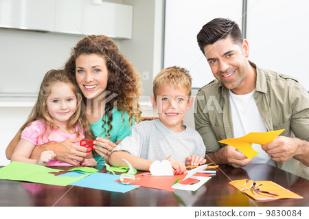 Smiling family doing arts and crafts together at the table Smiling family doing arts and crafts together at the table 9830084
