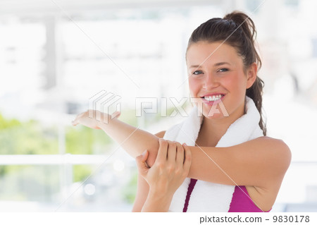 Portrait of a sporty woman stretching hand at yoga class 9830178