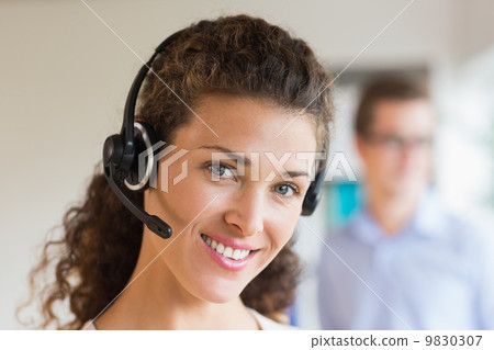 Female call center operator wearing headset Female call center operator wearing headset 9830307